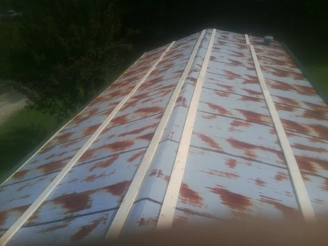 Rusted metal roof panels with new wood purlins before replacement — Storm Damage Roof Repair in Black Creek by Roofing Brothers